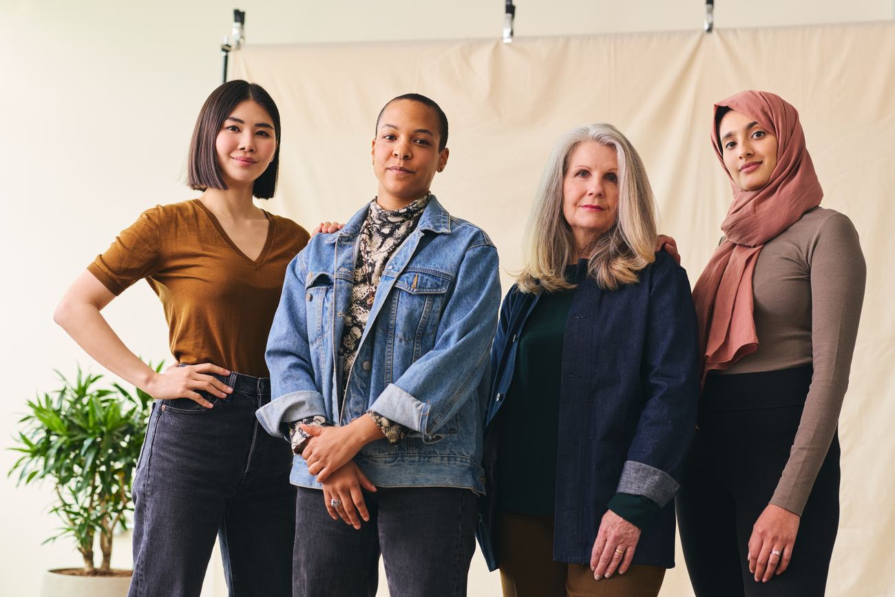 Four women standing together in solidarity